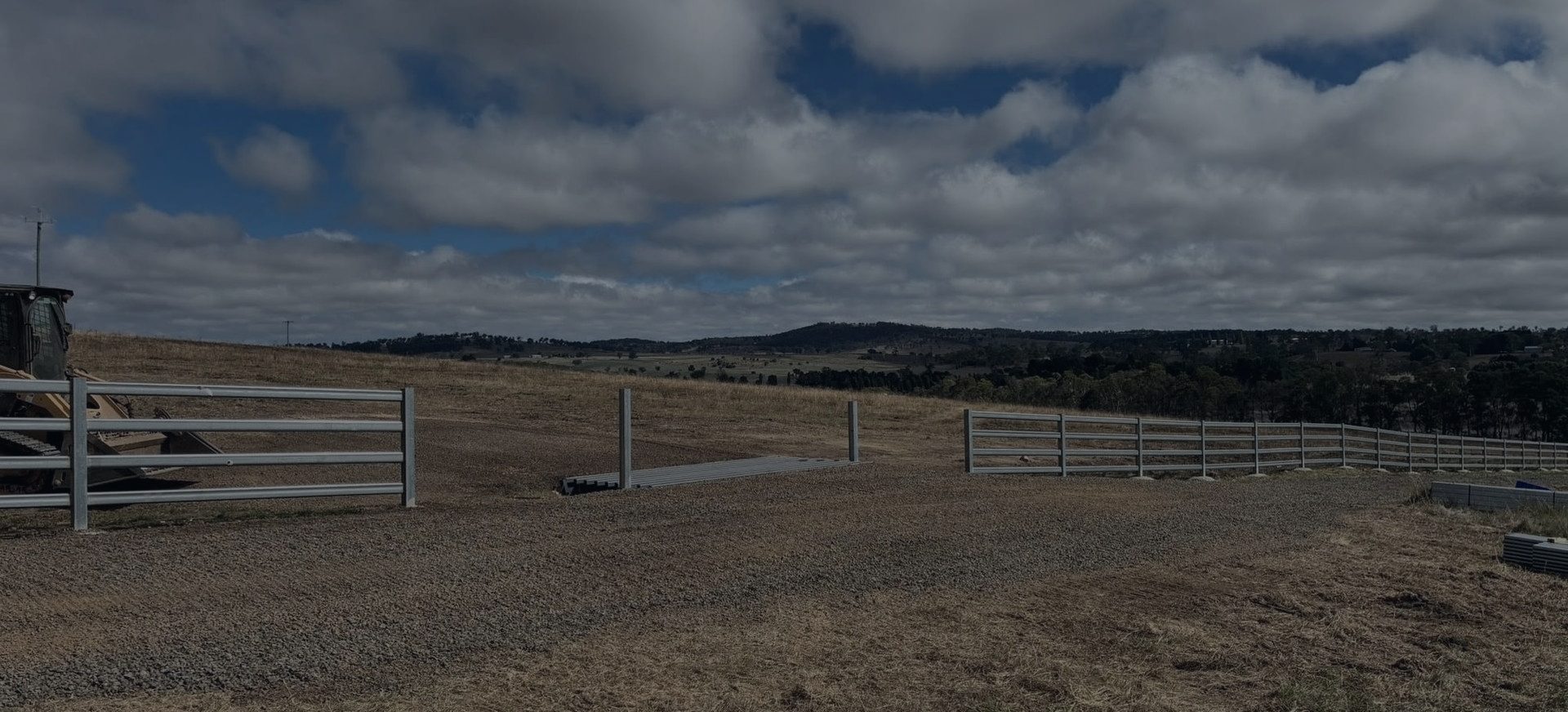 A new fence line and gate running out across open country under a big sky